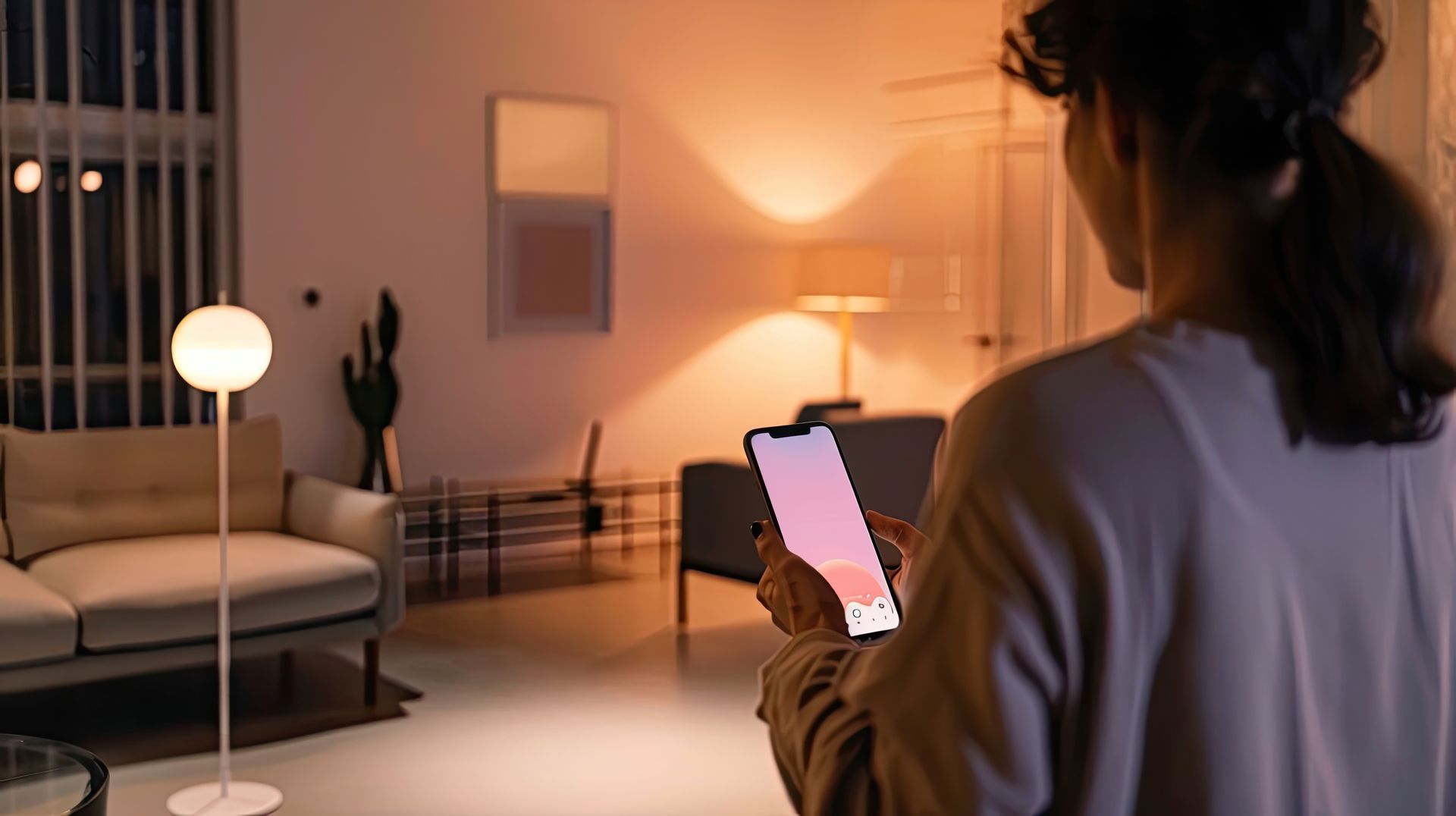 Dans un salon moderne éclairé par un lampadaire lumineux, une personne utilise son téléphone pour contrôler l'éclairage.