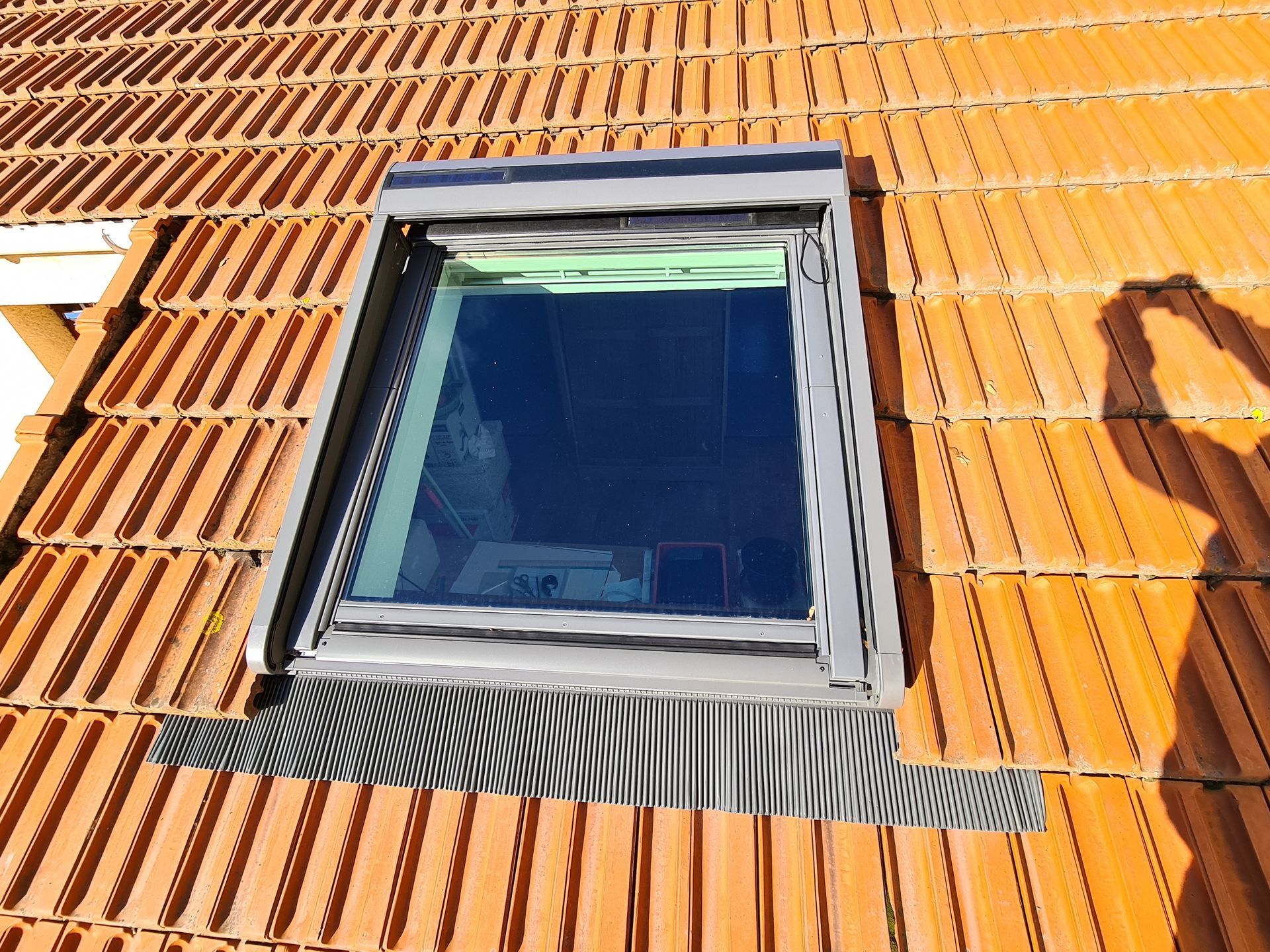 Plafond en bois avec fenêtre de toit ouverte sur le ciel bleu.