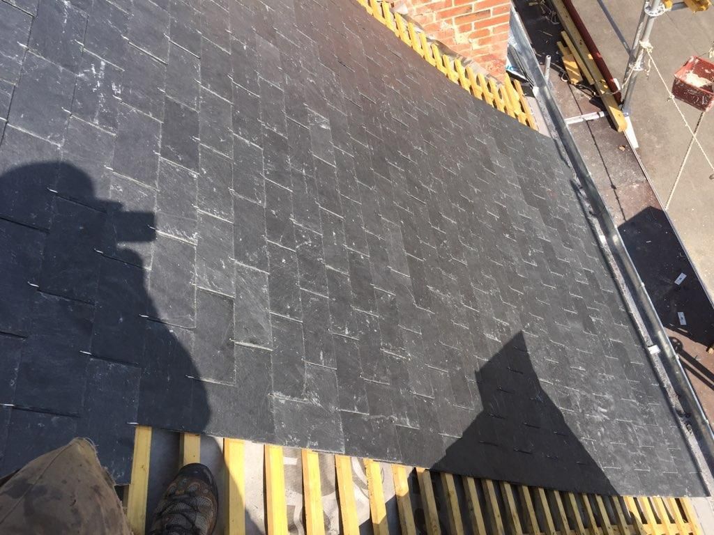 Toit en bardeaux noirs avec une bande de toiture non recouverte.