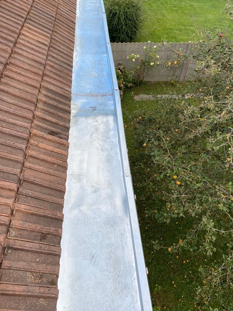 Gros plan sur le toit et la gouttière d'une maison.
