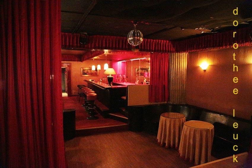 Ein dunkler Raum mit einem roten Vorhang und einer Discokugel