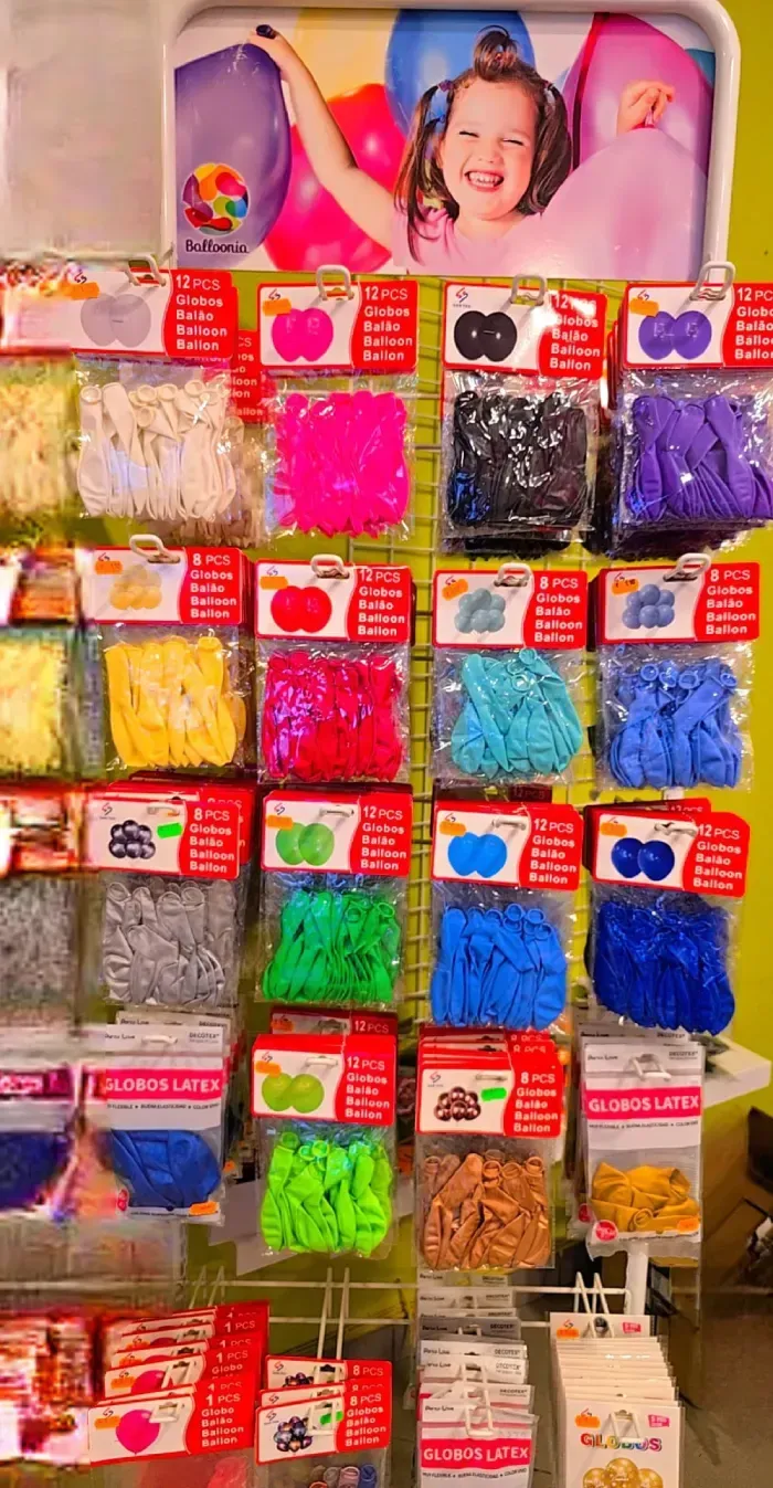 Estantes con decoraciones de fiesta coloridas, incluidos pompones