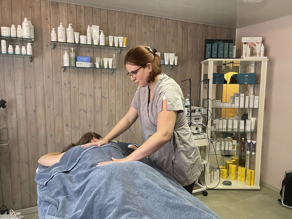 Une femme donne un massage à une femme dans un salon de beauté.