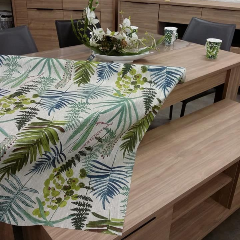 Décoration de table avec nappe à imprimé floral, meubles en bois et composition décorative.