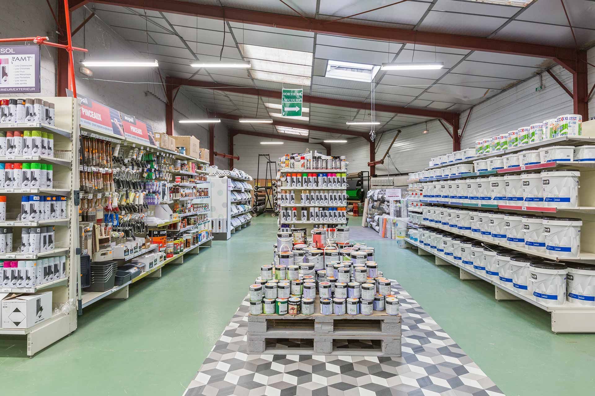Intérieur d'un magasin de peinture avec des étagères de pots de peinture et de fournitures.