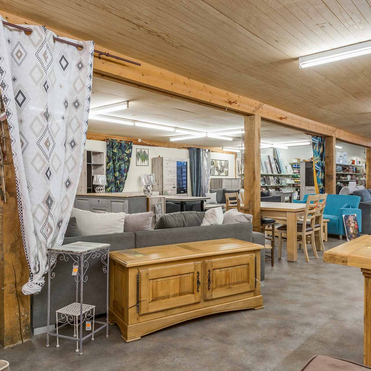 Une salle d'exposition de meubles avec une armoire en bois, un canapé et des chaises.