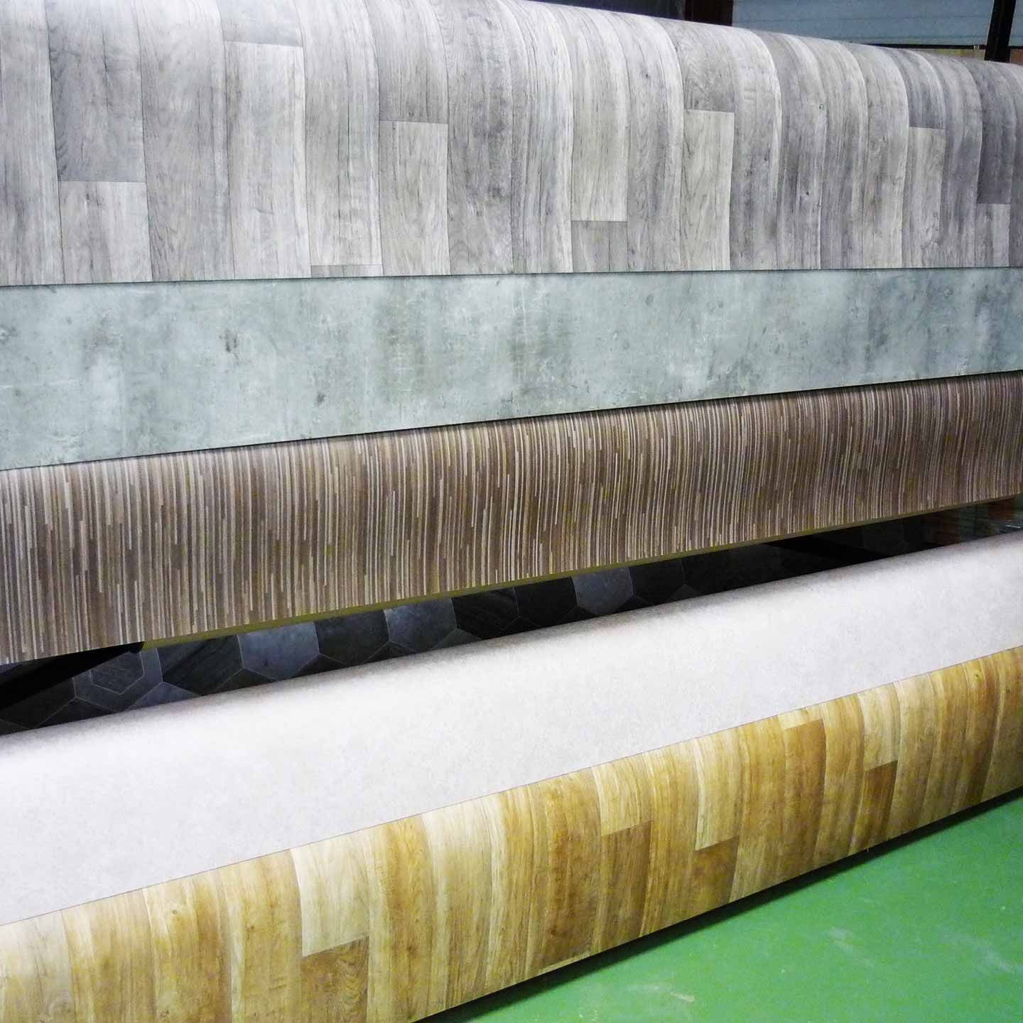 Gros plan de plusieurs rouleaux de revêtement de sol avec des motifs en grain de bois et à motifs.