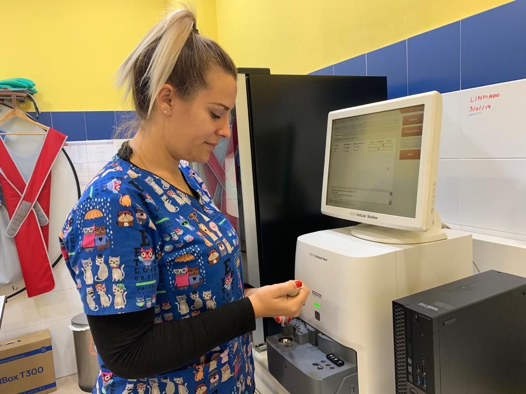 Una mujer con uniforme médico trabaja con una computadora en un laboratorio.