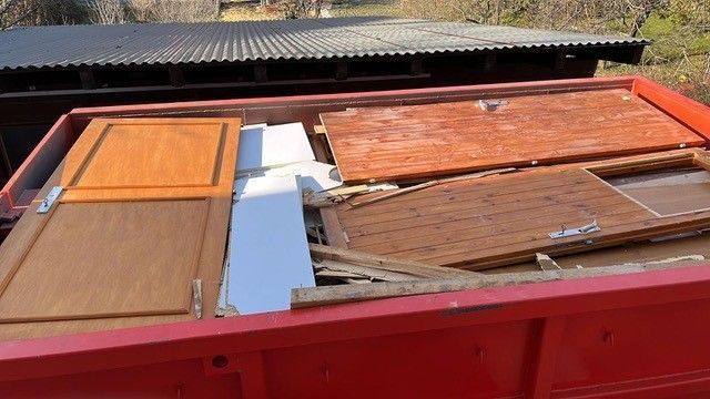 gros plan de l'intérieur d'une benne rouge rempli de planches abimées