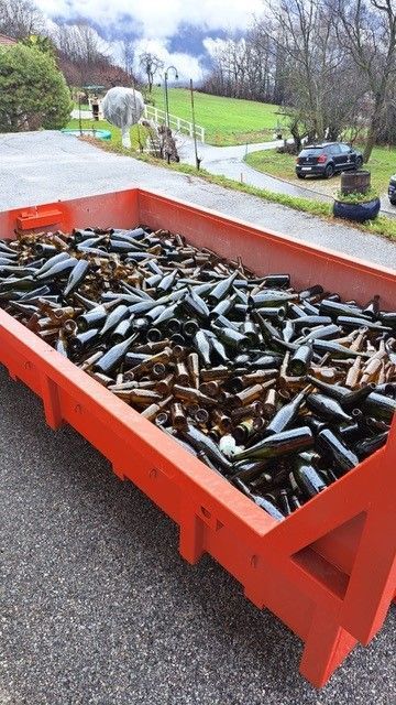 gros plan d'une benne rouge remplie de bouteilles vides en verre