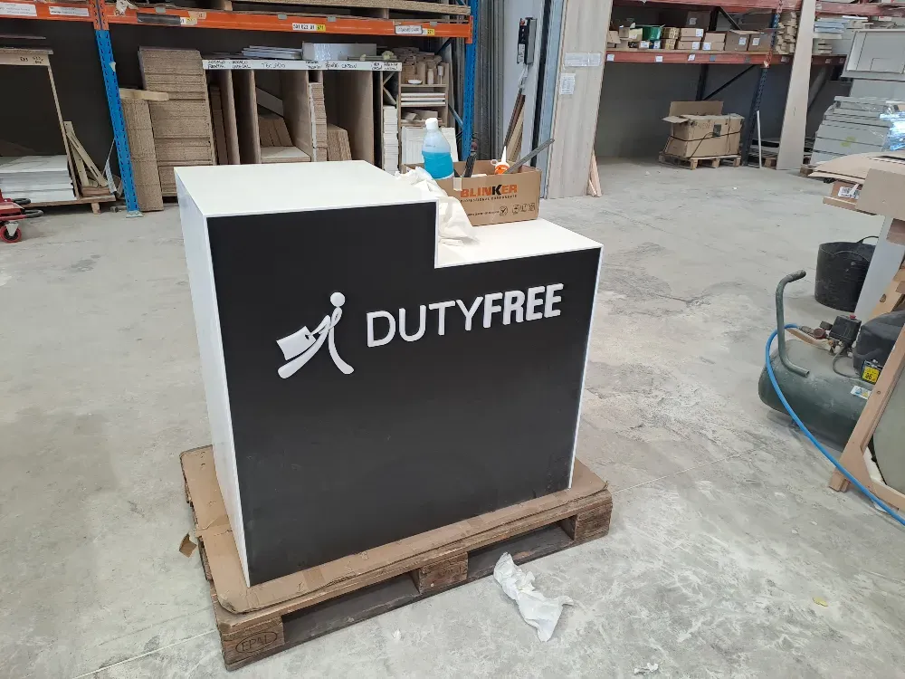 Quiosco Duty Free en blanco y negro sobre un palé de madera en un taller.