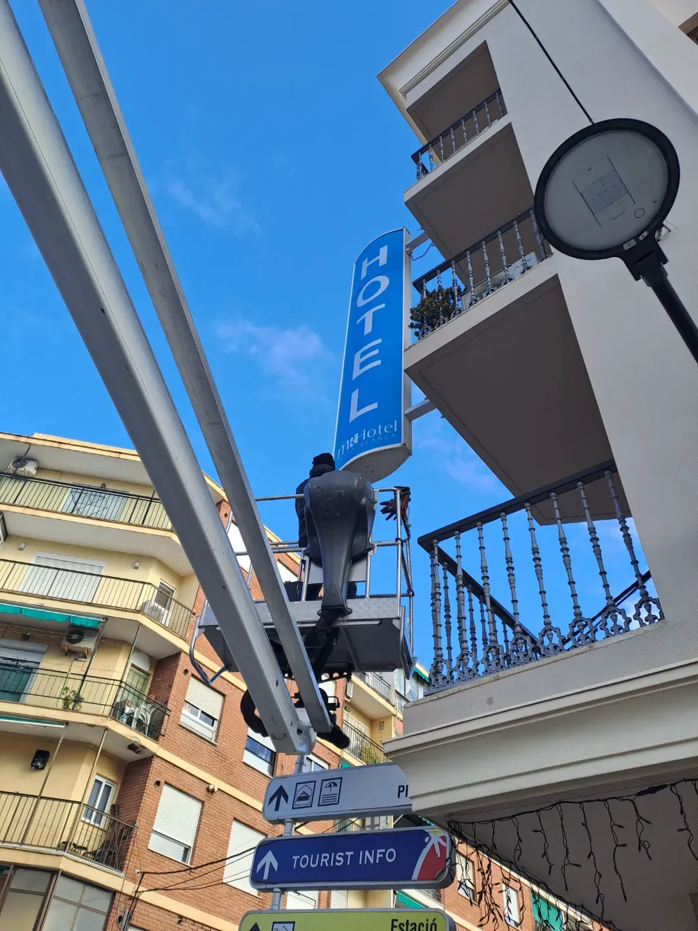 Hombre en un ascensor instalando el cartel de 