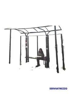 Una mujer está sentada en un banco debajo de un refugio.