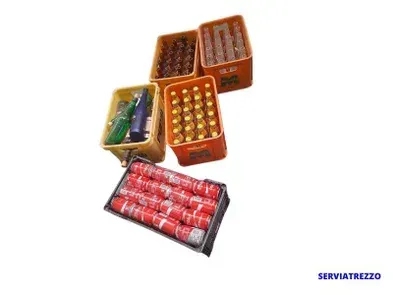 Un montón de cajas llenas de latas y botellas de Coca Cola.