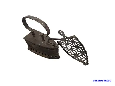 Una plancha y tabla de planchar muy antiguas con la palabra serviatrezzo en la parte inferior