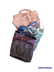 Un montón de bolsos están apilados uno encima del otro sobre un fondo blanco.