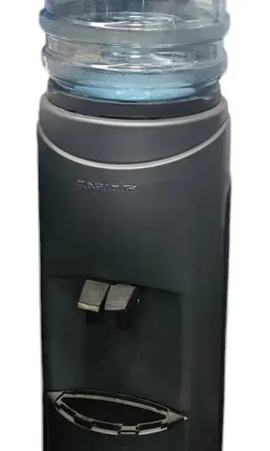 Un dispensador de agua negro con una botella de agua encima.