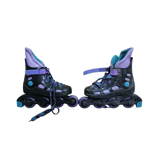 Un par de patines negros y morados sobre un fondo blanco.