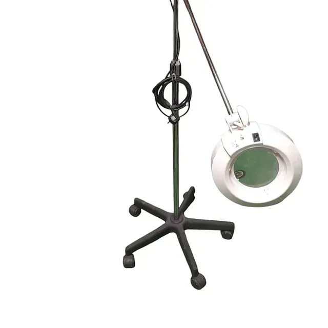 Una lupa cuelga de un soporte sobre un fondo blanco.