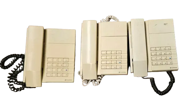 Tres teléfonos antiguos están alineados sobre un fondo blanco.