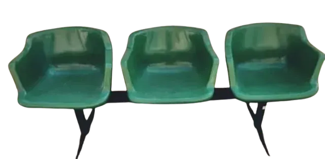 Una fila de sillas verdes sobre un fondo blanco.