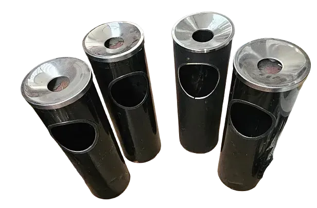 Un grupo de ceniceros negros con tapas plateadas sobre un fondo blanco.