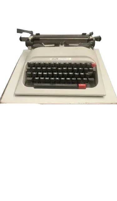 Una vieja máquina de escribir está sobre una mesa blanca.