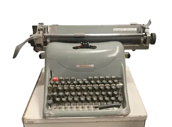 Una vieja máquina de escribir está encima de una caja blanca.