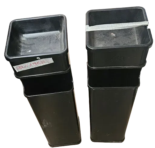 Dos contenedores de plástico negros están apilados uno encima del otro sobre un fondo blanco.