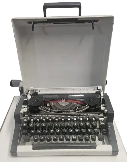 Una vieja máquina de escribir con la tapa abierta está sobre una mesa.