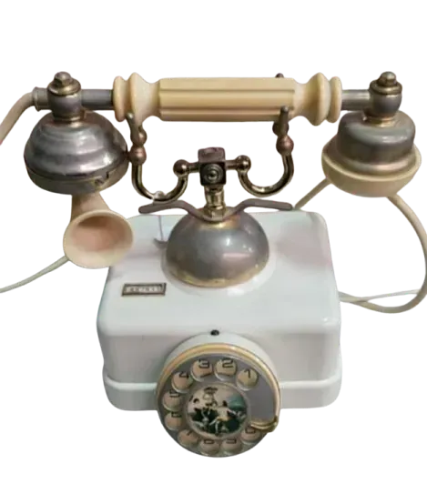 Un teléfono blanco antiguo con manija de latón.