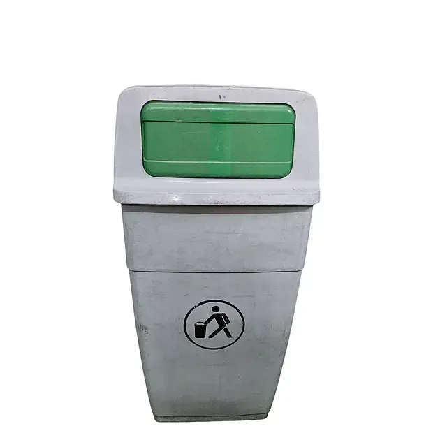 Un bote de basura con una tapa verde y un hombre que lleva un cubo sobre él.