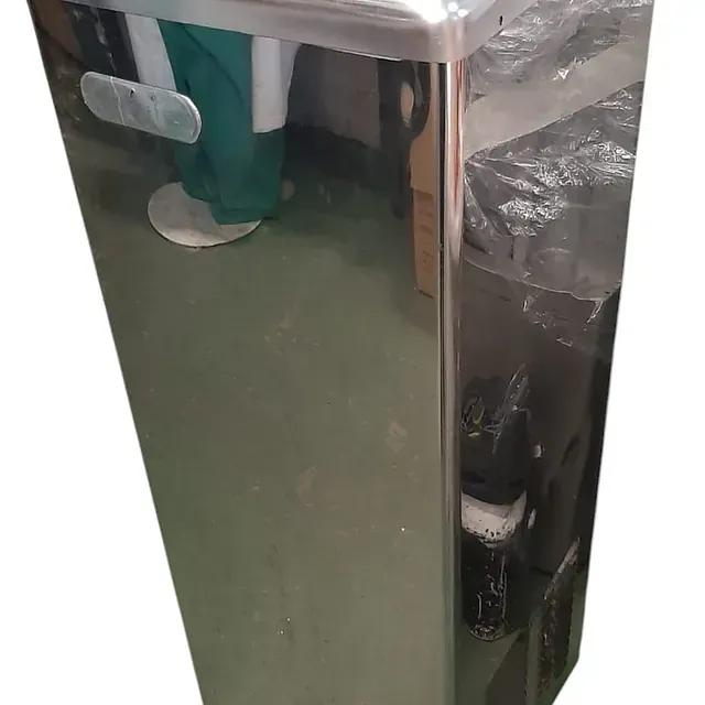 Una persona está parada frente a un refrigerador de acero inoxidable.