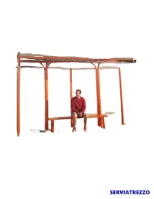 Un hombre está sentado en un banco de madera debajo de un refugio.