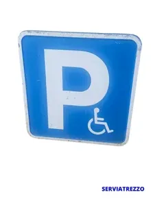 Un cartel azul con la letra p y una silla de ruedas encima.