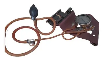 Un estetoscopio con una manguera conectada a él y un manómetro sobre un fondo blanco.