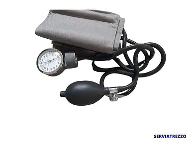 Un esfigmomanómetro está sobre una superficie blanca.