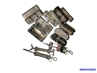 Un montón de instrumentos quirúrgicos están apilados uno encima del otro sobre un fondo blanco.