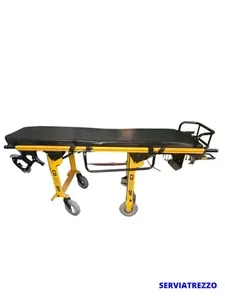 Una camilla negra y amarilla con ruedas sobre un fondo blanco.