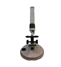 Un microscopio está colocado encima de una mesa sobre un fondo blanco.