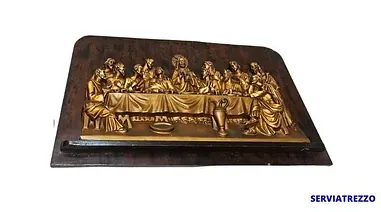 Una estatua de la última cena está sobre una mesa de madera.