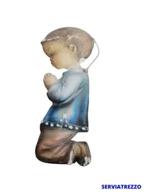 Una figura de un niño arrodillado rezando.