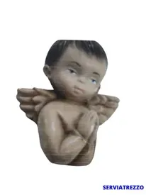 Una estatua de un niño con alas rezando.