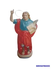 Una estatua roja y azul de Jesús sosteniendo un libro.