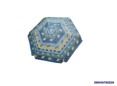 Un paraguas azul con un estampado reposa sobre una superficie blanca.