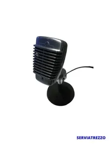 Un micrófono negro está sobre un soporte sobre un fondo blanco.