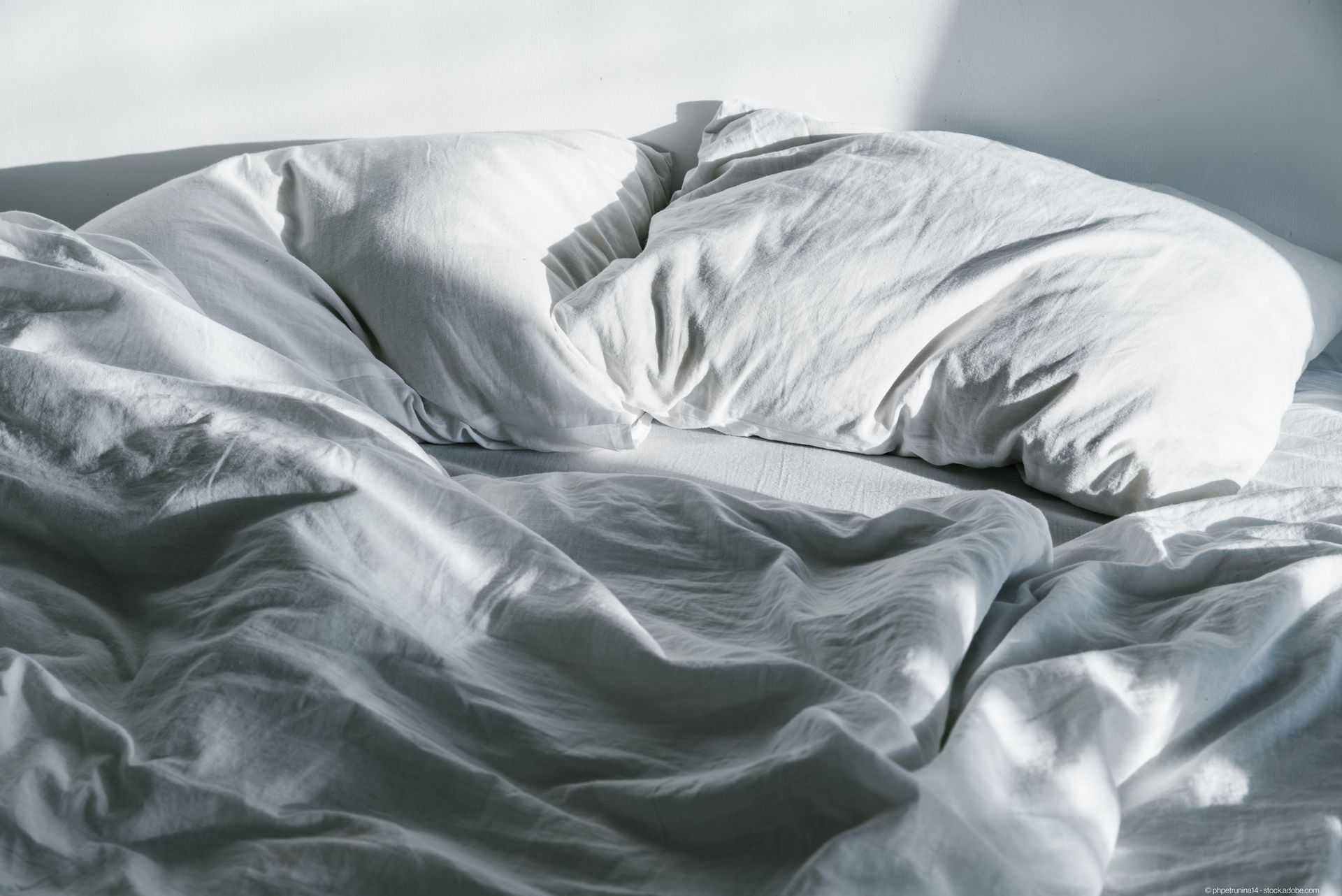 Zerknittertes Bett im Sonnenaufgang Sonnenlicht