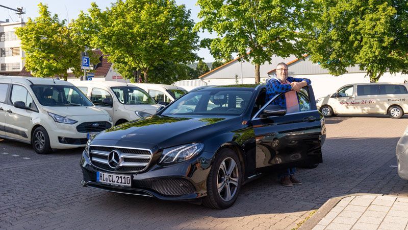 Ein Mann und eine Frau winken einem Taxi am Flughafen zu.