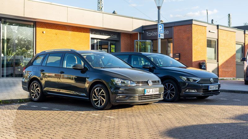 Ein Mann öffnet die Tür eines schwarzen Autos.