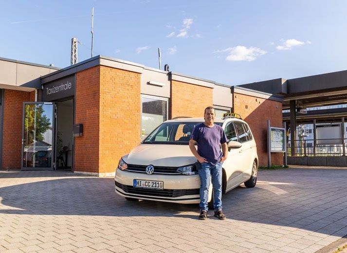 Ein Mann und eine Frau winken einem Taxi am Flughafen zu.